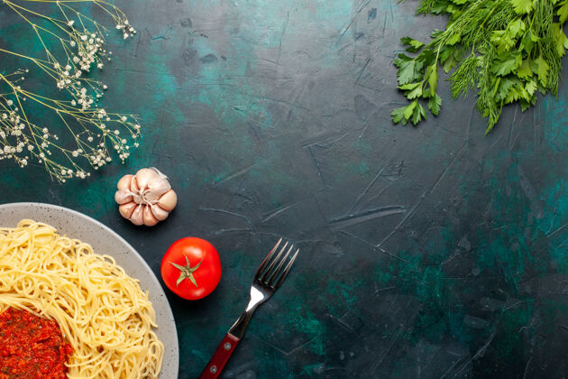 打击乐器俯视图：蓝色表面上有番茄酱肉末和绿色蔬菜的意大利熟面食肉末面食食物