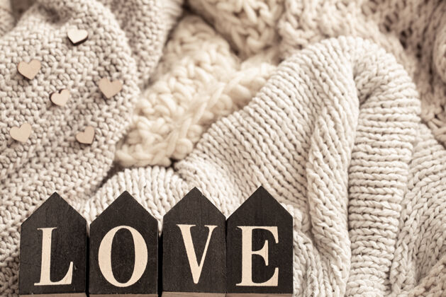 元素在舒适的针织物的背景上 木制字母组成了“爱”这个词木材编织爱情