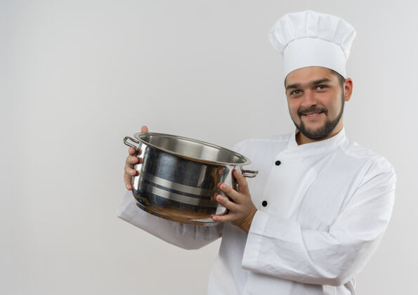厨师面带微笑的年轻男厨师 身着厨师制服 手拿锅碗瓢盆 在空白处显得孤立无援锅男性年轻