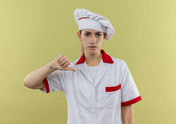厨师年轻漂亮的厨师穿着厨师制服 大拇指朝下 在绿地上显得孤立无援绿色向下显示