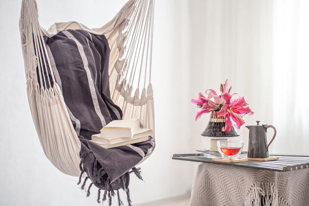 休息波西米亚风格的吊床椅 带书 茶壶和一杯茶休息和家庭舒适的概念地方房间细节