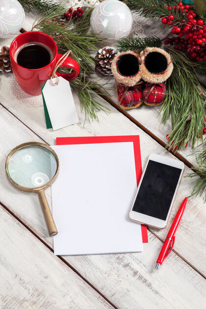 圣诞节一张白纸放在木桌上 上面有钢笔 电话和圣诞装饰品庆祝销售降临