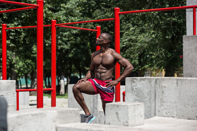 锻炼适合运动员在体育场做运动非裔或非裔美国男子在城市户外健康拉毅力