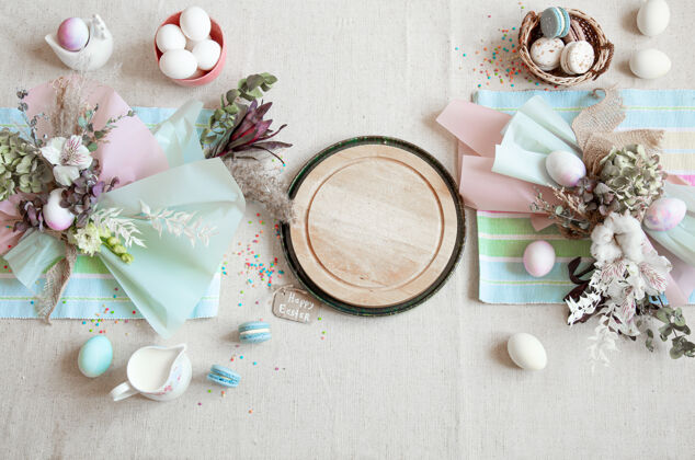 鸡蛋复活节的构图用花朵 彩蛋和木质空间为文字平铺上柔和的色彩细节桌子装饰