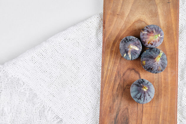 紫色木板上和白色的无花果热带健康零食
