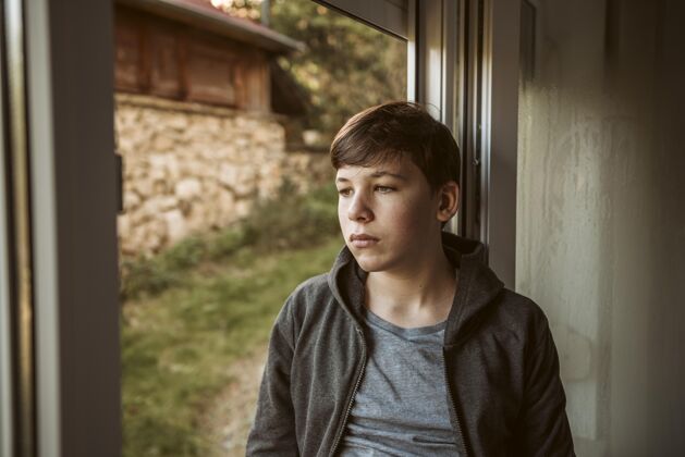 疾病前视图悲伤的男孩看外面爆发健康Ncov
