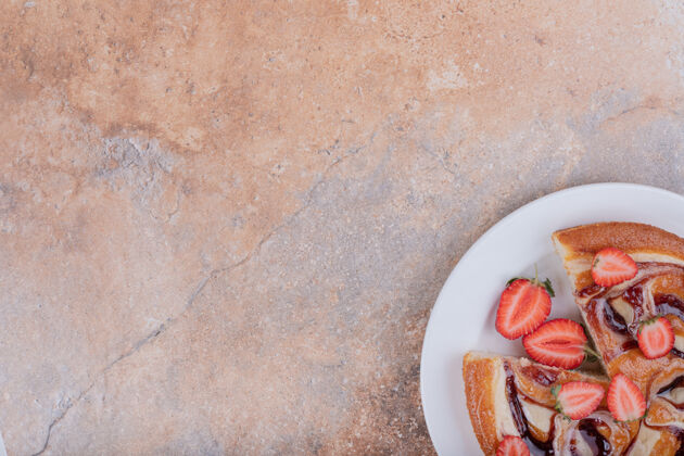 喜悦草莓派放在白色盘子里 周围有水果小吃糕点甜点