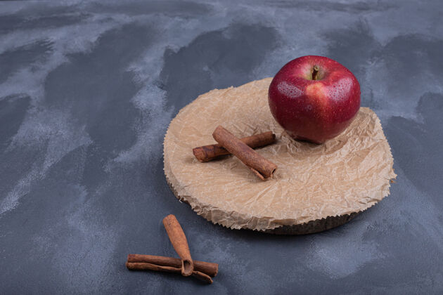 肉桂红苹果和肉桂在蓝色的表面木制板板多汁