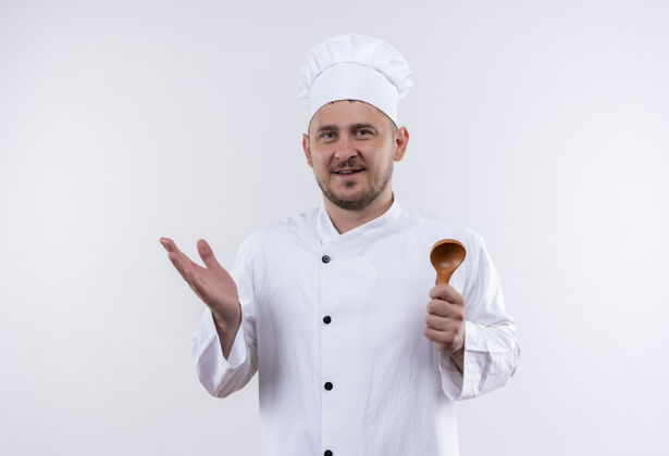 厨师高兴的年轻帅哥厨师穿着厨师制服拿着勺子 露出空手孤立在空白处勺子手空着