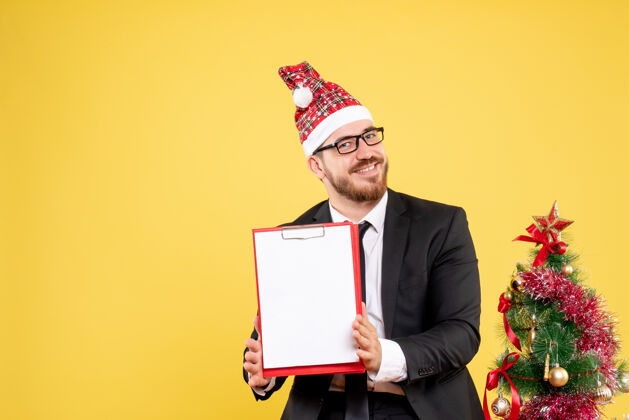 成功正面图：黄色背景下手持纸条微笑的男工人情感圣诞节公司