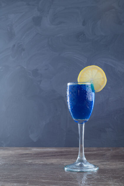 冷蓝色的水和柠檬在大理石墙上果汁柠檬水柑橘