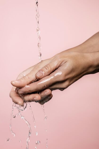 防护水倒在女人的手上流行病清洁清洗