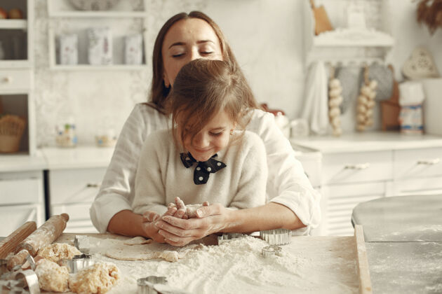 糕点一家人在厨房里漂亮的妈妈带着小女儿女儿面粉长