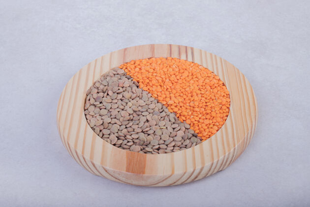 顶视图两种生豆和扁豆放在木盘里视野木质豌豆