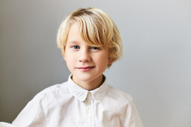 眨眼一个情绪化 开朗的蓝眼睛 金发的白人男孩的孤立形象 有着顽皮的面部表情孩子 自发性 快乐的童年和积极的情绪可爱童年积极