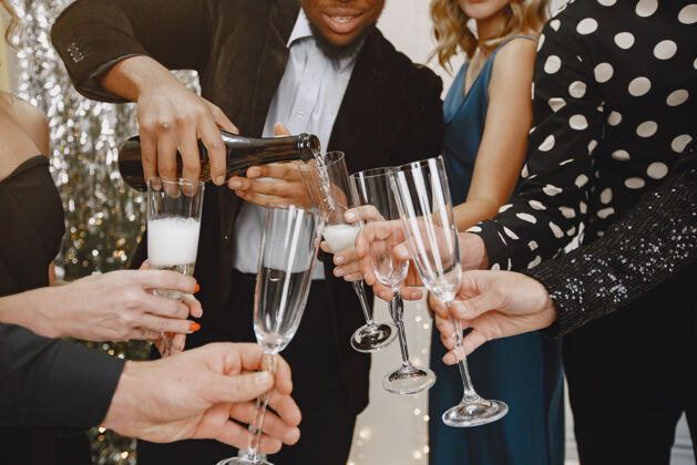 一起一群年轻人庆祝新年朋友们喝香槟玻璃新美国