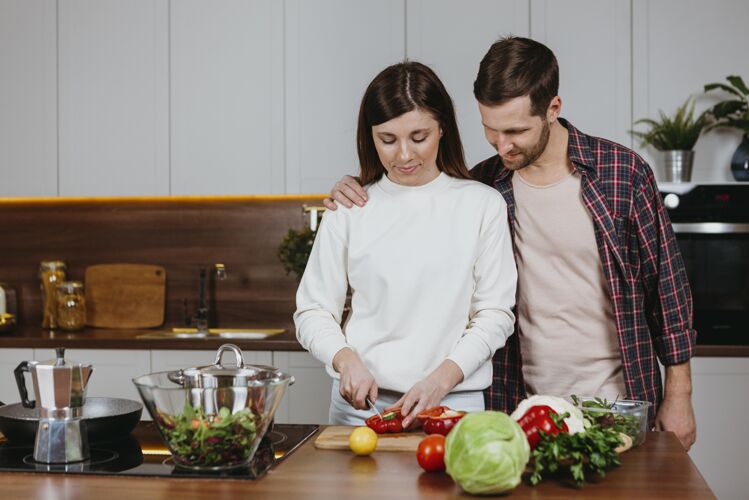 妈妈女人和男人在厨房准备食物的正面图妈妈前面蔬菜