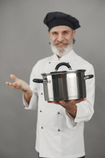 潘戴着金属锅的高级男人戴着黑帽子的厨师制服饮食胡须