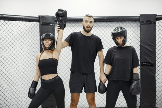 拳击手女子拳击裁判宣布冠军穿黑色运动服的女士女教练三活跃训练