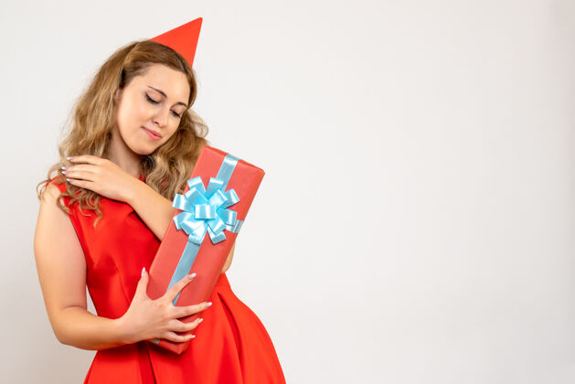 美丽正面图身着红色连衣裙的年轻女性用礼物庆祝圣诞节颜色成人年轻
