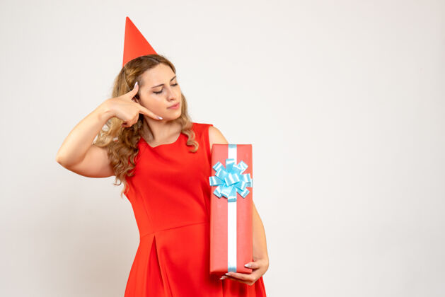 庆祝正面图身着红色连衣裙的年轻女性用礼物庆祝圣诞节夏娃服饰人物