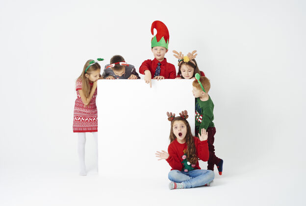 海报横幅和一群穿着圣诞服装的孩子们友谊庆祝圣诞节