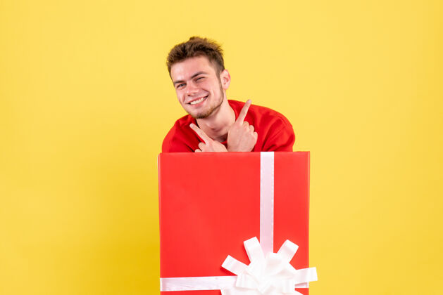 节日正面图穿红衬衫的年轻男子站在礼品盒内年情感年轻