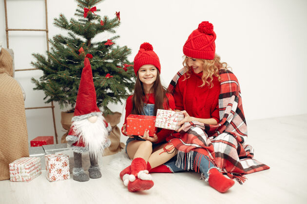 女孩人们在为圣诞节做准备母亲在和女儿玩耍一家人在节日的房间里休息孩子穿着红色毛衣肖像节日圣诞节