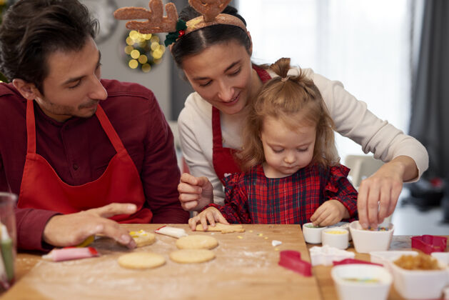 拥抱一家人一起在厨房装饰圣诞饼干家庭室内室内
