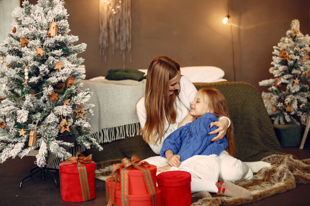 孩子人们在为圣诞节做准备母亲在和女儿玩耍一家人在节日的房间里休息孩子穿着蓝色毛衣庆祝人室内