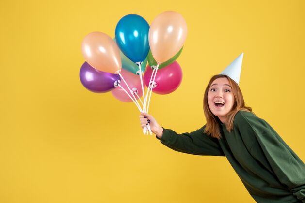 气球正面图：手持彩色气球的年轻女性圣诞节生日女性