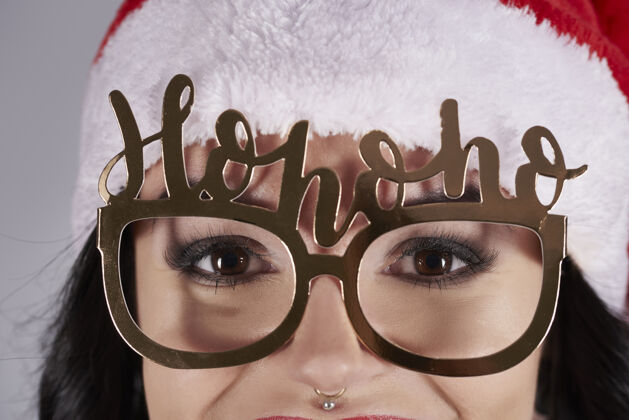 身体戴着圣诞帽和眼镜的女人的特写镜头美丽的人圣诞成人
