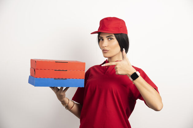 女人送货员指着比萨饼盒红色制服披萨快餐