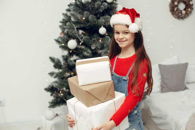 睡衣穿白色毛衣的孩子坐在圣诞树旁的女儿传统肖像童年