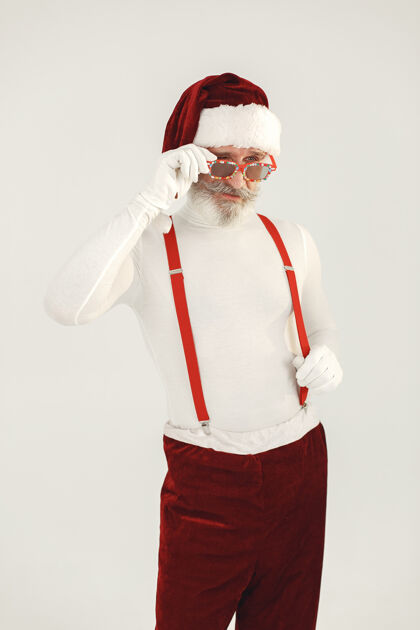 成熟时髦的灰色头发的圣诞老人男人穿针织衣服爷爷戴着圣诞老人的帽子节日节日事件