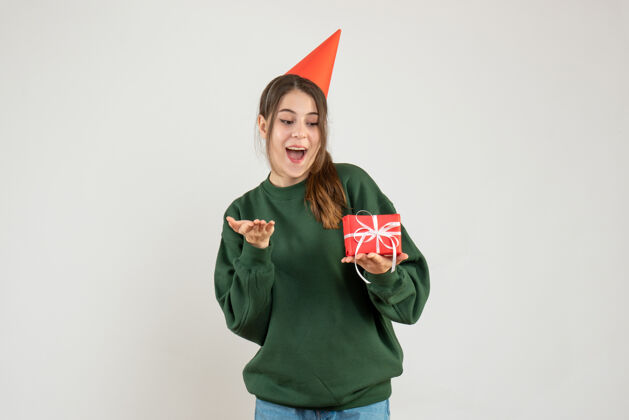肖像一个戴着派对帽的女孩拿着她的圣诞礼物圣诞节礼物举行