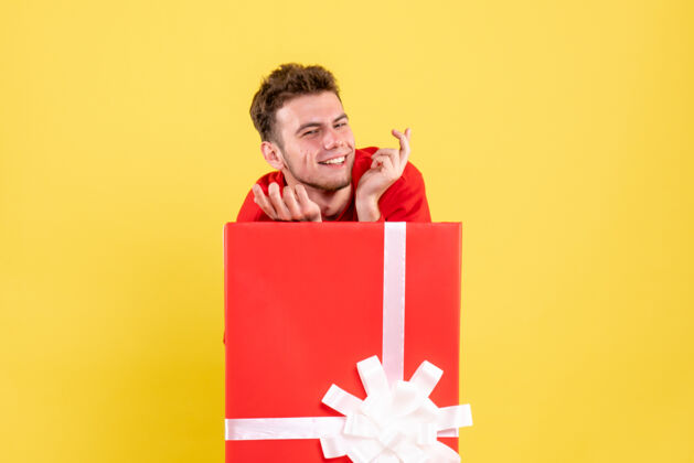情感正面图穿红衬衫的年轻男子坐在礼品盒内年轻男年轻圣诞节