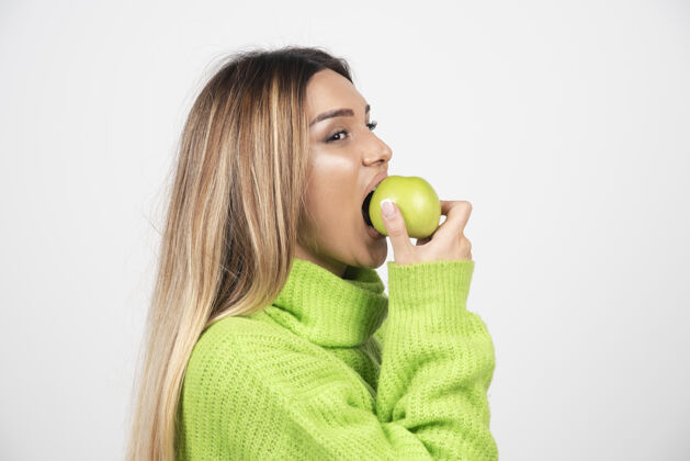 维生素穿着绿色t恤的年轻女子正在吃苹果肖像女人吃