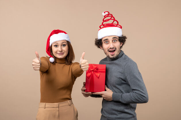 满意新年气氛喜庆的概念与搞笑满意幸福可爱的情侣戴着灰色的红色圣诞老人帽孩子圣诞老人心情