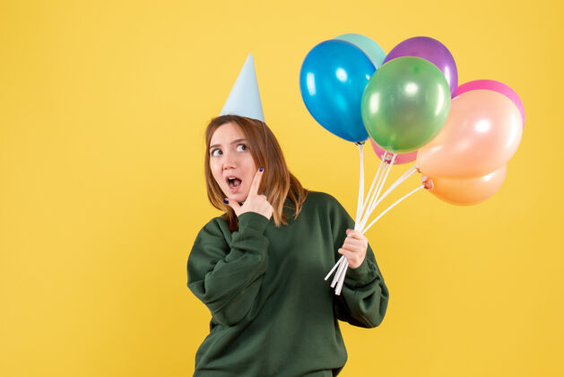 生日正面图是一位年轻的女士 手里拿着五颜六色的气球圣诞节吹年轻