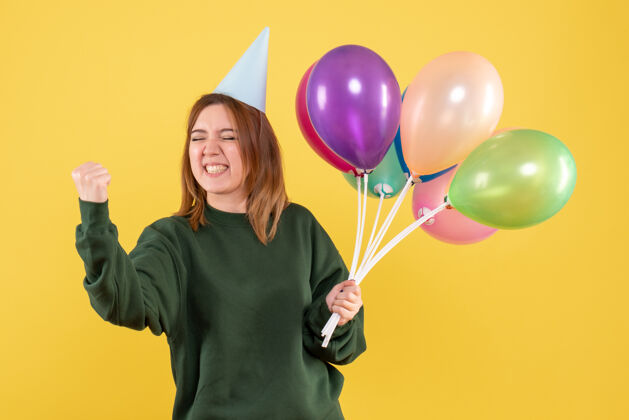生日正面图：带着彩色气球的年轻女性年乐趣空气