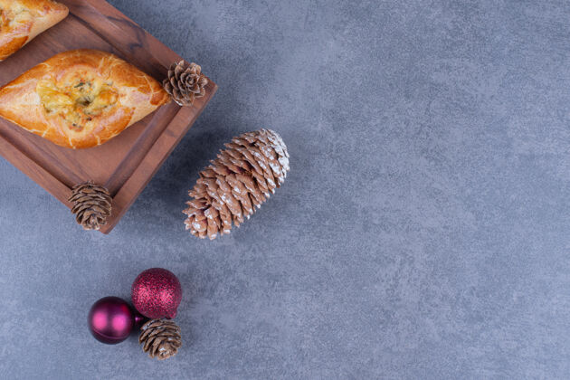 松果在木板上放圣诞球的美味糕点圆球松树吃