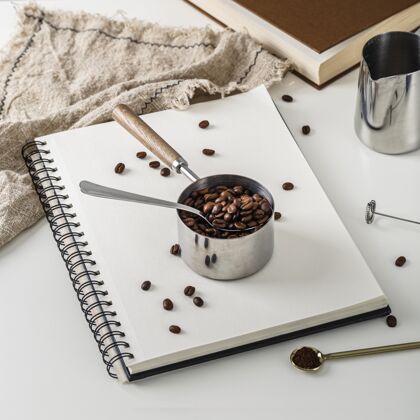 高角高角度的笔记本和一杯烤咖啡豆书籍杯子纺织品