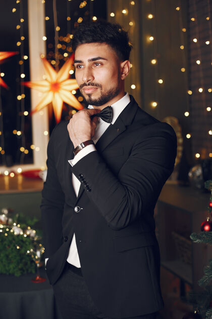 聚会圣诞树旁的帅哥穿着黑色西装的绅士黄金年轻事件
