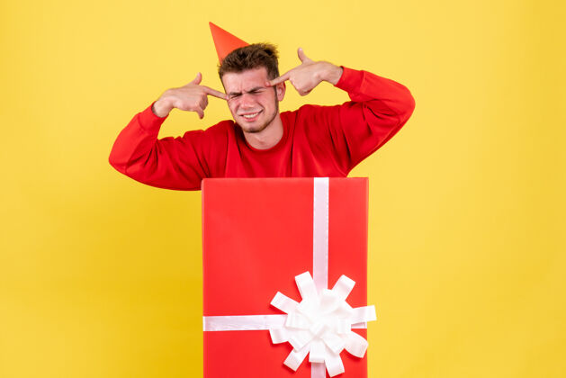 庆祝正面图：礼品盒内穿红色衬衫的年轻男性礼物购物内部