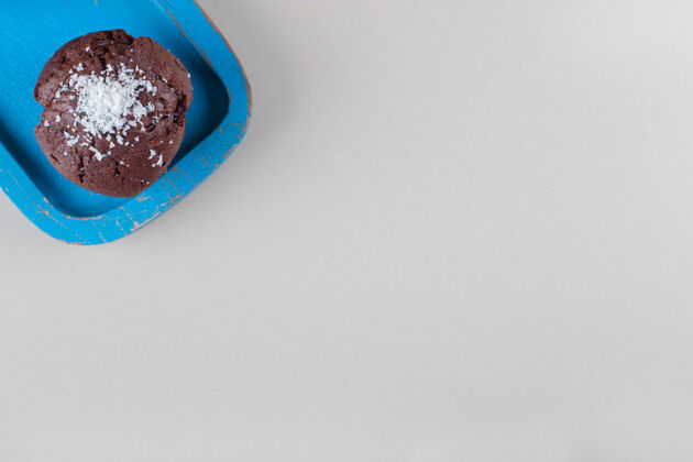 烘焙巧克力蛋糕放在大理石背景的蓝色盘子里粉末纸杯蛋糕糕点