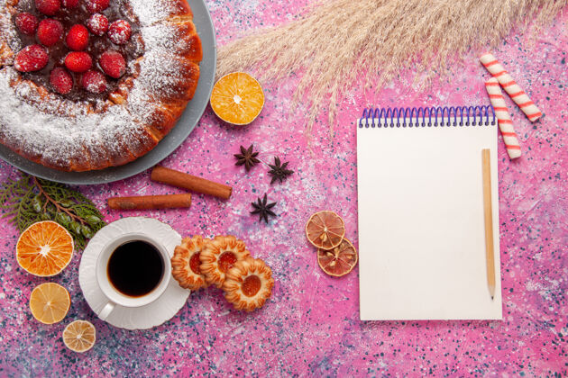茶俯瞰美味的草莓蛋糕 用糖粉和茶烤在浅粉色的背景蛋糕上 甜甜的糖饼干馅饼早餐杯子生的