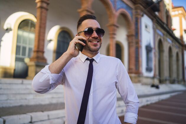 手机成功的年轻商人 一身正装 戴着墨镜打电话沟通工作企业家