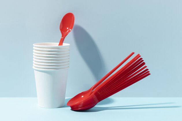 回收红色的小勺子和塑料杯废物塑料一次性