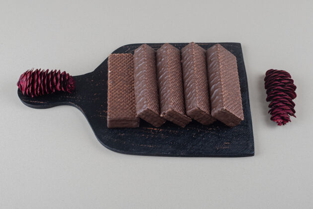 美味黑底白板上涂有巧克力的薄饼涂层甜点小吃